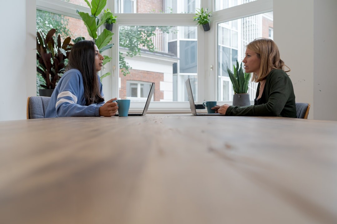 Two Brazilian women having a warm mentoring conversation at a table